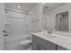 Well-lit bathroom features a shower-tub combo, modern fixtures, and vanity with gray cabinets at 1107 Depot Dr, Durham, NC 27703
