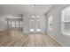 Dining area with wood-look flooring, a chandelier, and natural light from the windows and door at 1107 Depot Dr, Durham, NC 27703