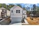Charming two-story home with a modern white exterior, complemented by a spacious driveway and manicured lawn at 1107 Depot Dr, Durham, NC 27703