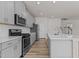 Modern kitchen with stainless steel appliances, gray cabinetry, and a center island with a sink at 1107 Depot Dr, Durham, NC 27703