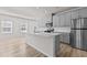 Well-lit kitchen with a spacious island, modern appliances, gray cabinets and laminate flooring at 1107 Depot Dr, Durham, NC 27703