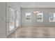 Bright living room features hardwood floors, a chandelier, and lots of windows with a french door on the left at 1107 Depot Dr, Durham, NC 27703