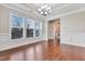 Bright dining room featuring hardwood floors, crown molding, large windows, and a stylish chandelier at 1109 Hemby Ridge Ln, Morrisville, NC 27560