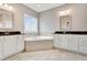 Well-lit bathroom with a large tub, double sinks, granite countertops and decorative window at 1109 Hemby Ridge Ln, Morrisville, NC 27560