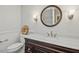 Bathroom showcasing marble countertop, dark cabinets, decorative mirror, and paneled wall accents at 14115 Allison Dr, Raleigh, NC 27615