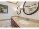 Bathroom featuring a granite countertop, double sinks, and framed oval mirrors at 14115 Allison Dr, Raleigh, NC 27615