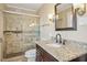 Bathroom featuring granite countertop, dark wood cabinets, and a tiled shower with glass door at 14115 Allison Dr, Raleigh, NC 27615