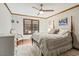 Bedroom with neutral walls, wood trim, ceiling fan, and a large window overlooking the backyard at 14115 Allison Dr, Raleigh, NC 27615