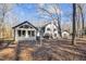 Rear exterior of a two-story home with a sunroom and a backdrop of mature trees at 14115 Allison Dr, Raleigh, NC 27615