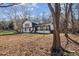 Exterior of home with a white facade, dark trim, complemented by the natural scenery and bare trees at 14115 Allison Dr, Raleigh, NC 27615