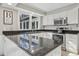 Well-lit kitchen boasts granite countertops, stainless steel appliances and white cabinetry at 14115 Allison Dr, Raleigh, NC 27615