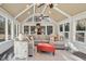 Bright sunroom with vaulted ceilings, expansive windows, and a cozy sectional sofa at 14115 Allison Dr, Raleigh, NC 27615