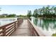 A tranquil pond view from a wooden dock with a fountain, surrounded by lush trees at 1501 Millrock Trl, Wendell, NC 27591