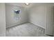 Well-lit bedroom with neutral carpet, white walls, and a window offering natural light at 1599 Rogers Pointe Ln, Creedmoor, NC 27522