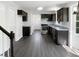 Modern kitchen featuring dark cabinetry, stainless steel appliances, and sleek hardwood floors at 1599 Rogers Pointe Ln, Creedmoor, NC 27522