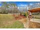 A backyard features a stone paved patio with an outdoor kitchen under a wooden pergola at 181 Steam Engine Way, Garner, NC 27529