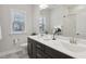 Bright bathroom featuring a double sink vanity, large mirror, and window with natural light at 1829 Knights Crest Way, Wake Forest, NC 27587