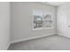 Bright bedroom with a large window providing natural light and plush gray carpeting at 1829 Knights Crest Way, Wake Forest, NC 27587