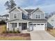 Attractive two-story home with gray siding, a welcoming front porch, and an attached two-car garage at 1829 Knights Crest Way, Wake Forest, NC 27587