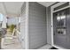 Charming front porch with gray siding, stone accents, a dark front door, and classic white rocking chairs at 1829 Knights Crest Way, Wake Forest, NC 27587