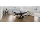Bright game room featuring a pool table, hardwood floors, and a comfy white couch at 1829 Knights Crest Way, Wake Forest, NC 27587