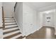 Hallway with hardwood floors, staircase, white doors, and view of the entrance creating a bright and spacious feel at 1829 Knights Crest Way, Wake Forest, NC 27587