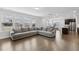 Open-concept living room features hardwood floors, many windows, and a large sectional sofa at 1829 Knights Crest Way, Wake Forest, NC 27587