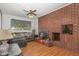 Inviting living room with a striking brick fireplace, hardwood floors, and lots of natural light at 2005 Sutphin Dr, Sanford, NC 27330