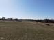 Drone shot showcasing a vast field with a home and wooded areas in the distance at 2113 Nc 55, Coats, NC 27521
