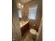 Bright powder room with a single sink vanity, wood-look floors, and natural light at 2113 Nc 55, Coats, NC 27521