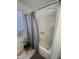 Bathroom with white tiled floors, neutral color walls, shower with gray-striped shower curtain and handheld shower head at 2113 Nc 55, Coats, NC 27521
