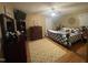 Bedroom with wood flooring, large bed with patterned duvet and shams, ceiling fan and dresser at 2113 Nc 55, Coats, NC 27521