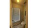 Small powder room with a toilet, single window with blinds, and a door at 2113 Nc 55, Coats, NC 27521