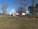 This home boasts a spacious yard with mature trees, a circular driveway, and an attached garage at 2113 Nc 55, Coats, NC 27521
