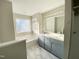 Bathroom featuring double vanity, soaking tub under frosted window and marble tile floor at 2114 Stoney Spring Dr, Raleigh, NC 27610