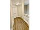 Upstairs hallway with wood-look floors, storage closet, and white painted trim at 2114 Stoney Spring Dr, Raleigh, NC 27610
