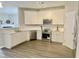 Bright kitchen features white cabinets, stainless steel appliances, light countertops, and wood-look flooring at 2114 Stoney Spring Dr, Raleigh, NC 27610
