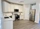 Bright kitchen features white cabinets, stainless steel appliances, light countertops, and wood-look flooring at 2114 Stoney Spring Dr, Raleigh, NC 27610