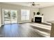 Living room with fireplace, ceiling fan, sliding doors to backyard, and wood-look floors at 2114 Stoney Spring Dr, Raleigh, NC 27610