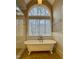 Soaking tub by a window next to frameless shower, complete with wainscoting for a luxurious experience at 216 Copper Beech Ct, Chapel Hill, NC 27517