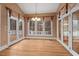 Bright dining area featuring a chandelier and multiple French doors leading to an outdoor deck at 216 Copper Beech Ct, Chapel Hill, NC 27517