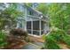 Charming home exterior featuring a screened-in porch and a backyard surrounded by lush greenery, offering privacy and tranquility at 216 Copper Beech Ct, Chapel Hill, NC 27517