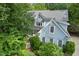 Stunning exterior featuring blue siding surrounded by mature trees and landscaping at 216 Copper Beech Ct, Chapel Hill, NC 27517