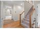 Inviting foyer with hardwood floors, staircase with carpet runner, and view into another carpeted room at 216 Copper Beech Ct, Chapel Hill, NC 27517