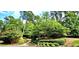 Beautifully landscaped front yard with mature trees, manicured bushes, and well-maintained lawn at 216 Copper Beech Ct, Chapel Hill, NC 27517