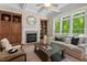 Bright living room boasts a fireplace, custom built-ins, and oversized windows offering beautiful outdoor views at 216 Copper Beech Ct, Chapel Hill, NC 27517
