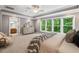 Bright main bedroom featuring a sitting area, windows with wooded views, and ensuite bathroom access at 216 Copper Beech Ct, Chapel Hill, NC 27517