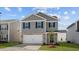 Charming two-story home with gray siding, brick details, an attached garage and front lawn at 258 Palm Dr, Sanford, NC 27332