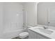 Modern bathroom featuring sleek white fixtures, a shower-tub combo, and a stylish vanity at 260 Logan Creek Dr, Zebulon, NC 27597