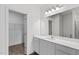 Bright bathroom featuring a long vanity with a sink, large mirror, and closet at 260 Logan Creek Dr, Zebulon, NC 27597